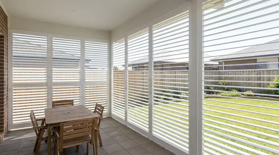 Powder-coated aluminium plantation shutters shading an outdoor deck from direct afternoon sun