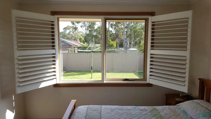 Hinged shutter panels in a bedroom