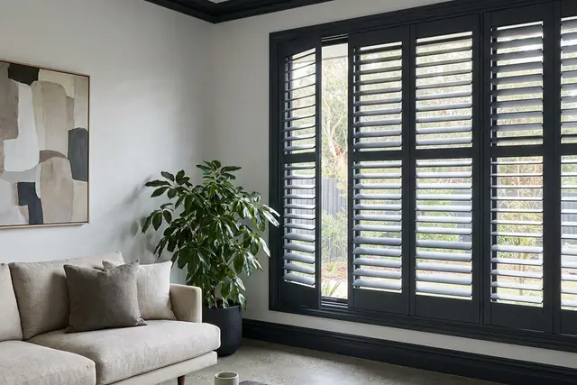 Charcoal plantation shutters colour matched to the trim in a contemporary living room